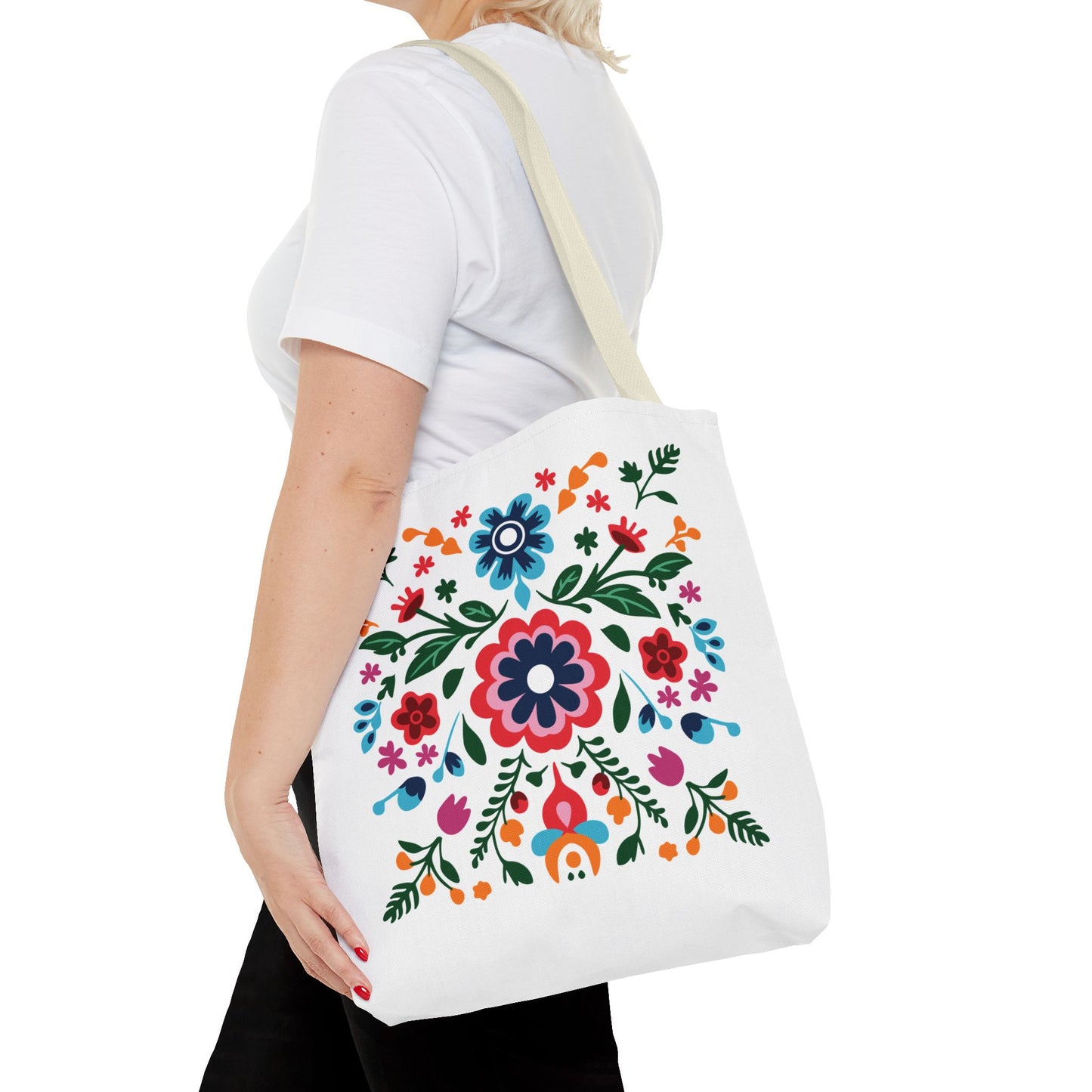 Floral Tote Bag: A woman carries a white tote adorned with vibrant flowers, exemplifying FireBrook Essentials' blend of style, durability, and joyful design.
