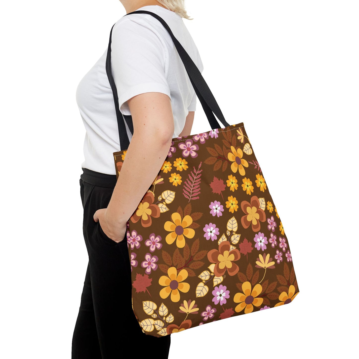 A person carries the Floral Tote Bag, showcasing vibrant retro-style flowers on a dark brown background, perfectly embodying FireBrook Designs' cheerful and stylish ethos for summer outings and market trips.