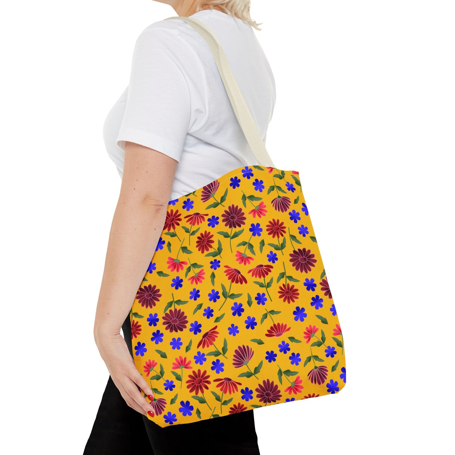 Golden Wildflower Tote Bag: A vibrant yellow canvas tote adorned with red and pink flowers, featuring sturdy off-white shoulder straps. Perfect for daily errands, embodying FireBrook Designs' cheerful and practical style.