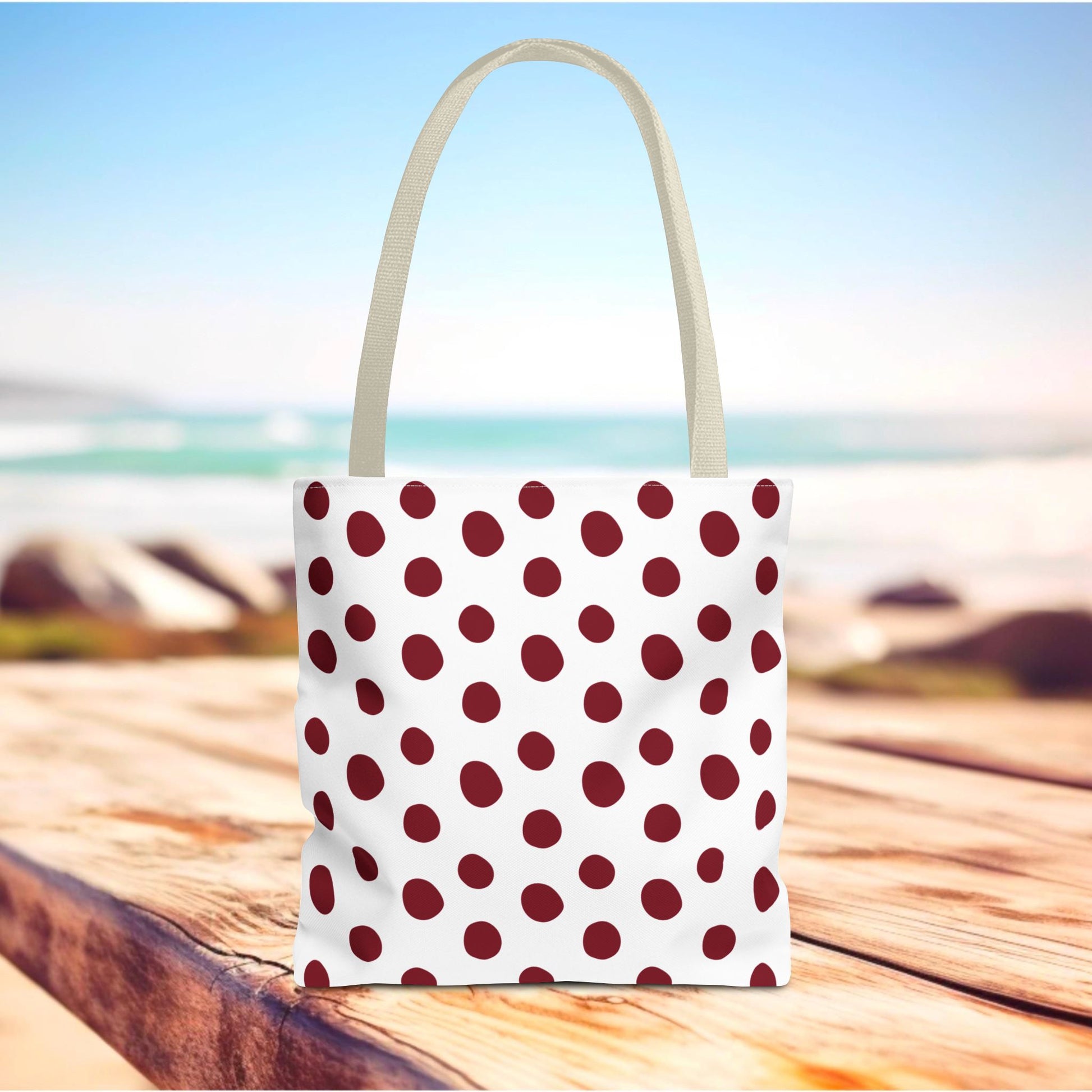 Burgundy Polka Dots Tote Bag on a wooden table, featuring durable polyester fabric with red dots, ideal for everyday use. A stylish accessory for shopping or travel, aligned with FireBrook Essentials' joyful design ethos.