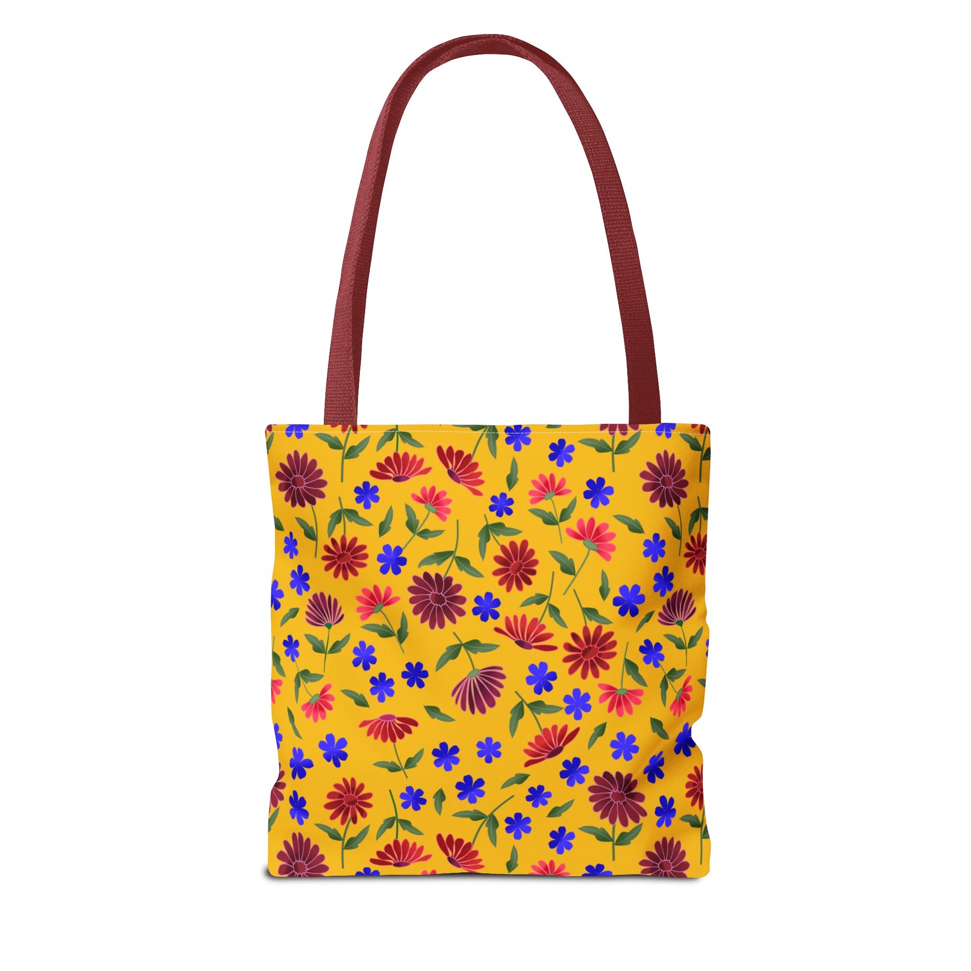 Golden Wildflower Tote Bag with a mustard-yellow backdrop adorned with red daisies, blue blooms, and green leaves. Features burgundy shoulder straps, embodying FireBrook Designs' vibrant, joyful style for versatile everyday use.