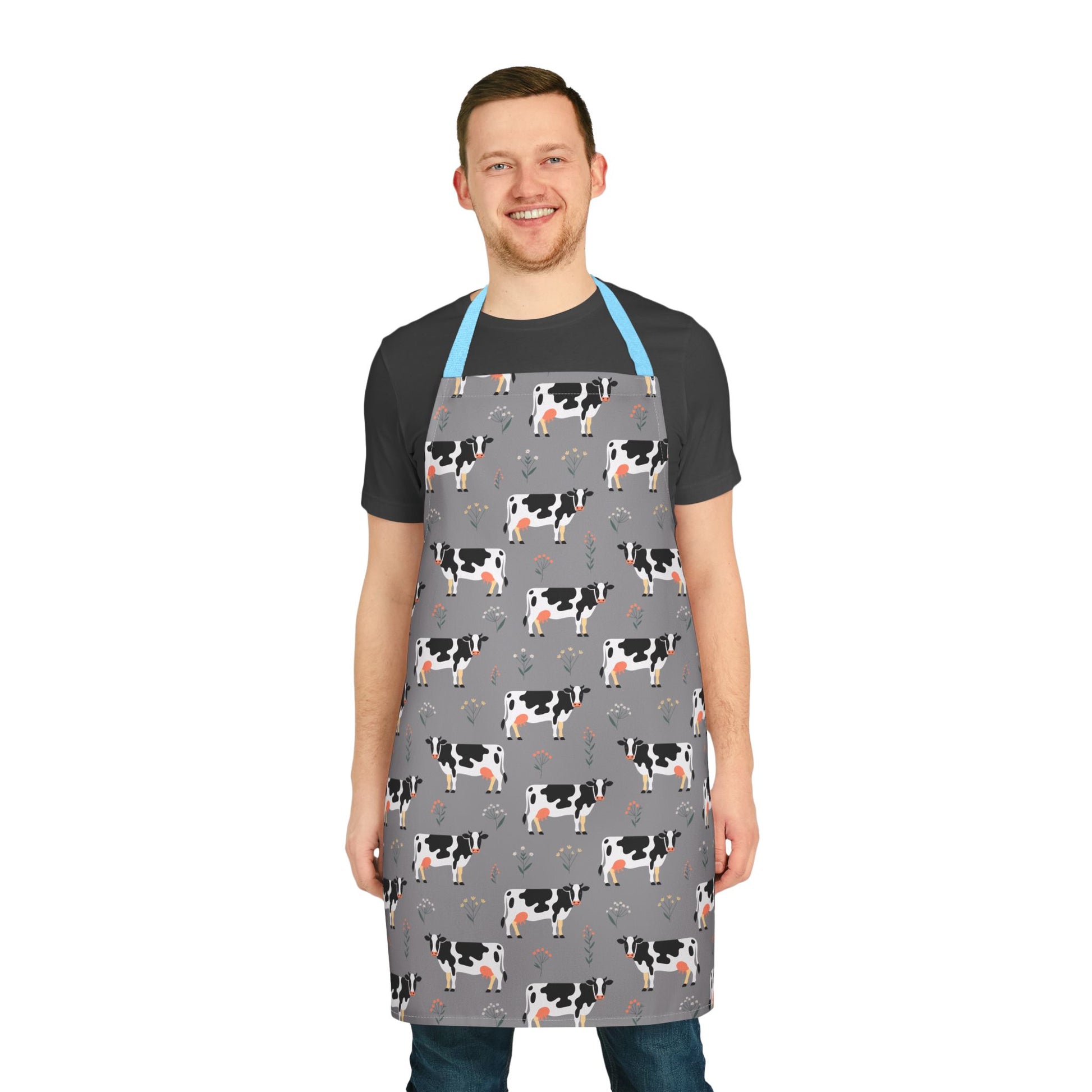Apron Dairy Cows Pattern: A man wears an apron featuring a charming Holstein cow design, ideal for cooking and crafting, reflecting FireBrook Designs' commitment to stylish, joyful living essentials.