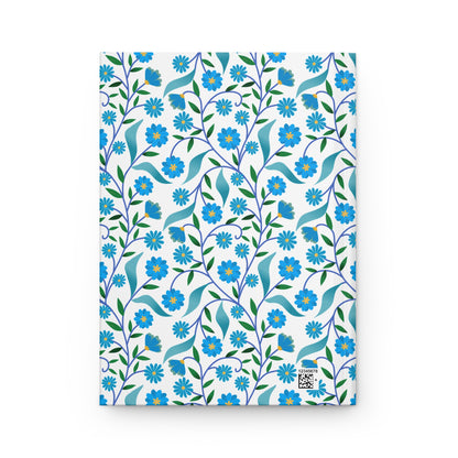 HARDCOVER JOURNAL, MATTE, RULED, 5X7, SEWN BIND, CLEAN-TEAR PAGES – BLUE DAISY VINE features a floral pattern of blue daisies and vines on a white cover, with a tiny QR code and numeric code.