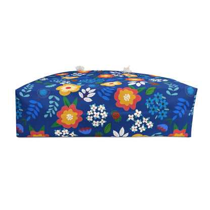 Weekender Bag with vibrant floral print on cobalt blue, featuring tassels. Ideal for stylish travel, showcasing FireBrook Designs' commitment to joyful, original designs.