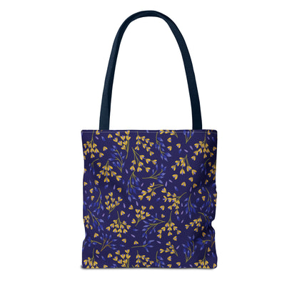 Floral Tote Bag featuring a deep blue-purple body with a vibrant botanical pattern of yellow and bluish sprigs, complemented by long, dark handles, perfect for cheerful, stylish outings.