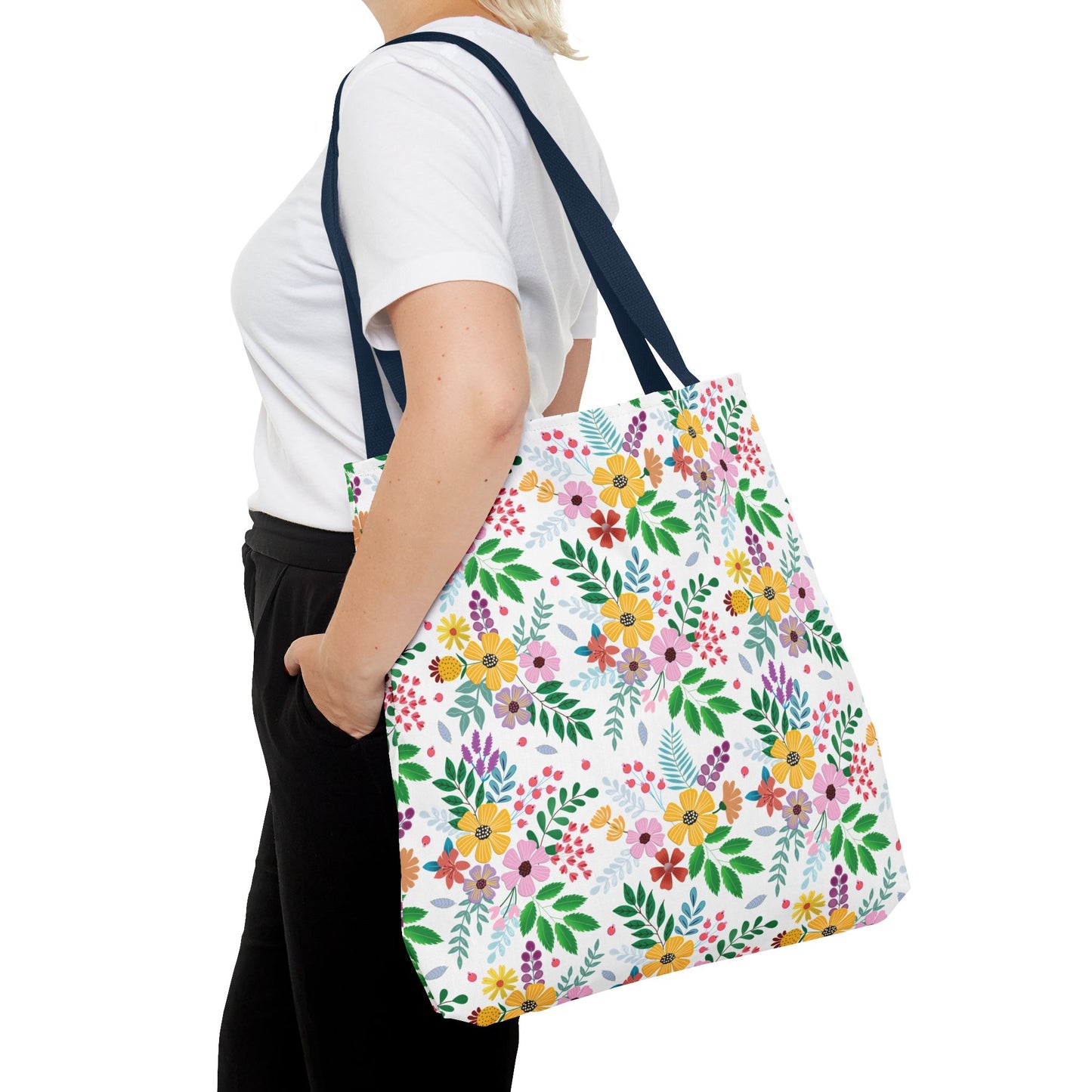Spring Floral Patch Tote Bag, adorned with vibrant blossoms and green leaves, is slung over a shoulder, showcasing its colorful pattern and sturdy design ideal for cheerful summer outings.