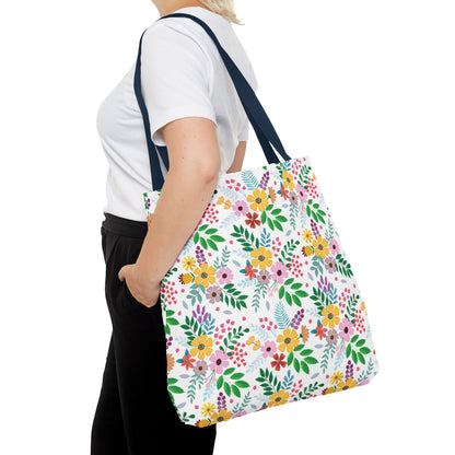Spring Floral Patch Tote Bag, adorned with vibrant blossoms and green leaves, is slung over a shoulder, showcasing its colorful pattern and sturdy design ideal for cheerful summer outings.
