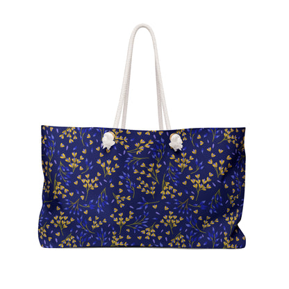 Weekender Bag with a dark-blue leaf-patterned fabric, featuring sturdy white rope handles. Spacious, ideal for stylish travel, embodying FireBrook Essentials' joyful design ethos.