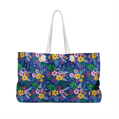 Weekender Bag with vibrant floral pattern and sturdy white rope handles, ideal for stylish travel. Features a spacious interior and T-bottom design, reflecting FireBrook Essentials' commitment to joy and comfort.