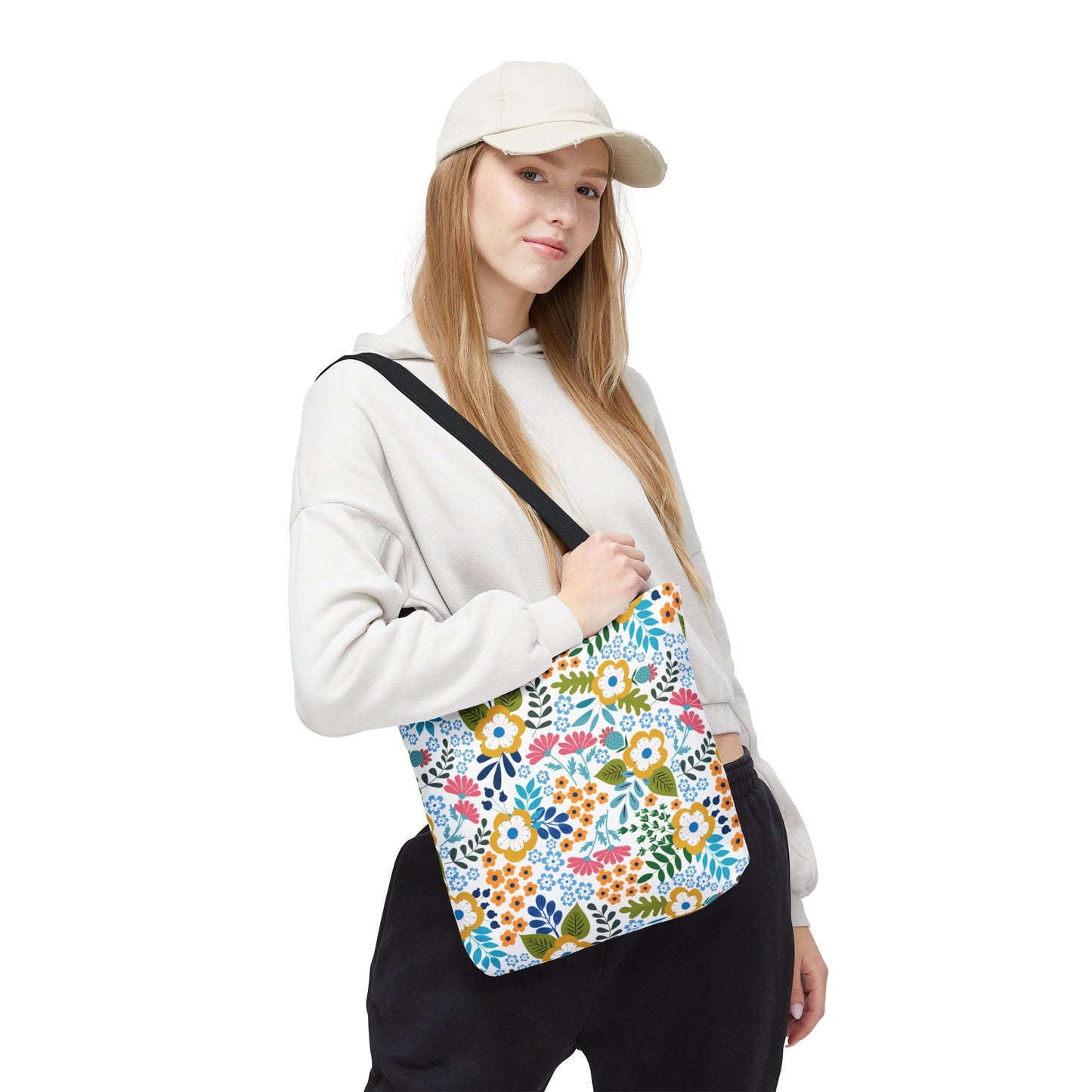 A young woman models a Floral Tote Bag, showcasing its vibrant floral pattern. Ideal for summer, the tote complements her casual outfit, embodying FireBrook Designs' commitment to joyful, stylish essentials.