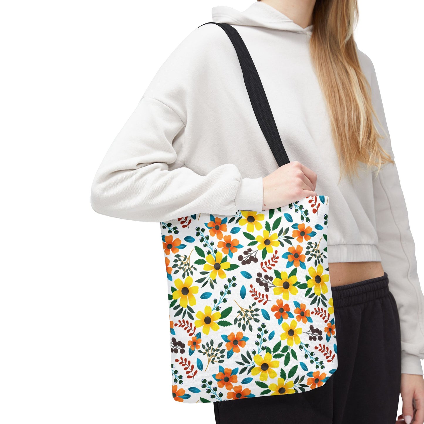 Sunny Meadow Mix Tote Bag featuring vibrant yellow and orange flowers, green leaves, and blue accents, carried by a person. Ideal for summer outings, showcasing FireBrook Designs' joyful and uplifting style.