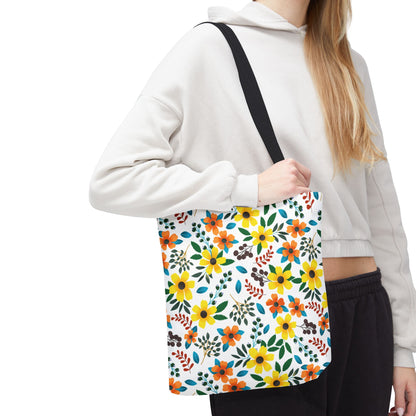 Sunny Meadow Mix Tote Bag featuring vibrant yellow and orange flowers, green leaves, and blue accents, carried by a person. Ideal for summer outings, showcasing FireBrook Designs' joyful and uplifting style.