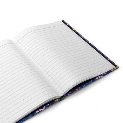 HARDCOVER JOURNAL, MATTE, RULED, 5X7, SEWN BIND, CLEAN-TEAR PAGES – MIDNIGHT BLOOM, featuring a dark-blue cover with colorful florals, open to show lined pages, perfect for capturing thoughts.