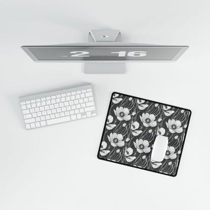 Monochrome Poppies Floral Desk Mat features intricate poppy line art on a keyboard, enhancing workspace aesthetics with its minimalist style, perfect for gifting and adding elegance to any desk setting.