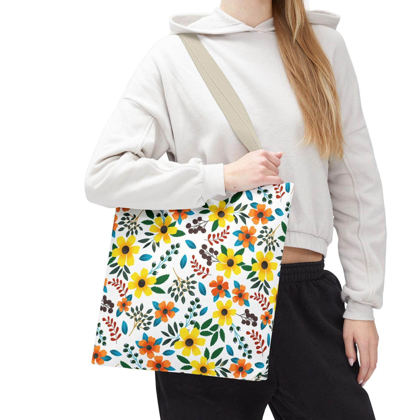 Floral Tote Bag with vibrant yellow and orange flowers, carried by a person in a light hoodie, epitomizes FireBrook Designs' joyful, stylish essence—ideal for summer outings with its durable polyester and reinforced stitching.
