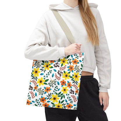 Floral Tote Bag with vibrant yellow and orange flowers, carried by a person in a light hoodie, epitomizes FireBrook Designs' joyful, stylish essence—ideal for summer outings with its durable polyester and reinforced stitching.