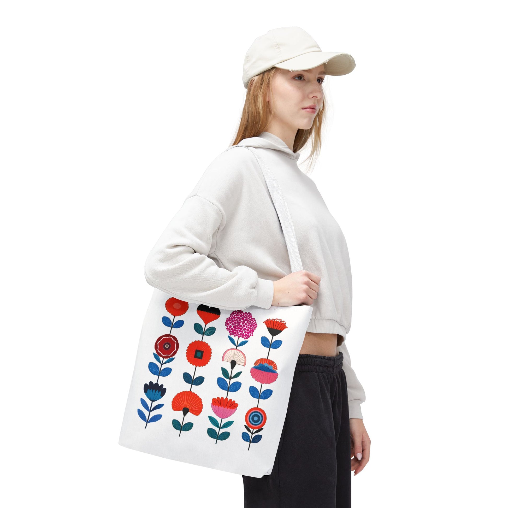 Woman in white hat holding a Floral Pattern Tote Bag with flower design, embodying spring charm and functionality from FireBrook Essentials.