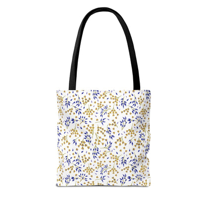 Wild Herb Garden Tote Bag featuring a white background with a gold and deep blue botanical pattern. The bag has black shoulder straps, offering a vibrant, stylish companion for summer outings.
