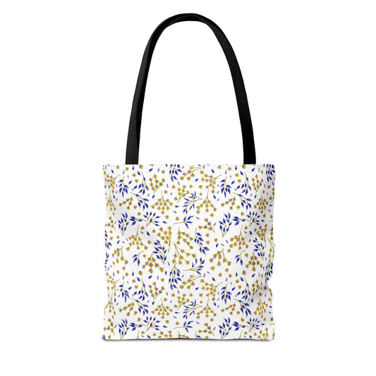 Wild Herb Garden Tote Bag featuring a white background with a gold and deep blue botanical pattern. The bag has black shoulder straps, offering a vibrant, stylish companion for summer outings.