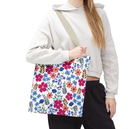 Person holding a Floral Tote Bag with bright floral pattern, ideal for summer outings. The tote bag features durable polyester, reinforced stitching, and boxed corners, embodying FireBrook Designs' focus on style and joy.