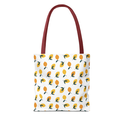Lemon Drop Toss Tote Bag with a lively lemon motif on a white background, featuring maroon/red straps. Ideal for joyful outings, embodying FireBrook Designs' cheerful and practical style.