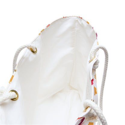 Weekender Bag with cream lining viewed from above, showcasing thick rope handles through brass grommets and hints of a colorful leaf-print pattern on the outer sides, ideal for stylish travel.