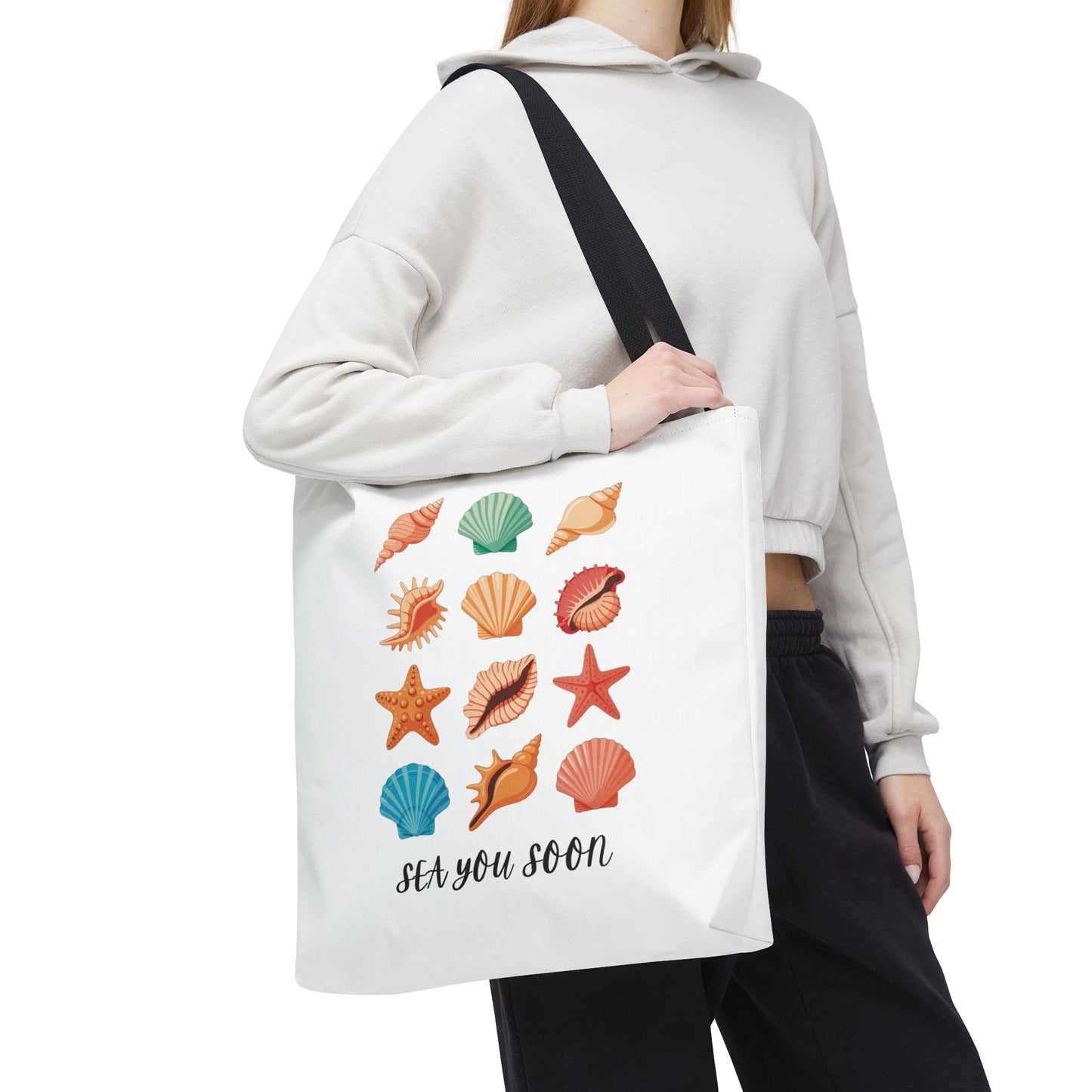 Sea You Soon Sea Shells Tote Bag with beachy design, featuring seashell graphics. Ideal for coastal outings, it offers durability with polyester body, reinforced handles, and boxed corners for extra space.
