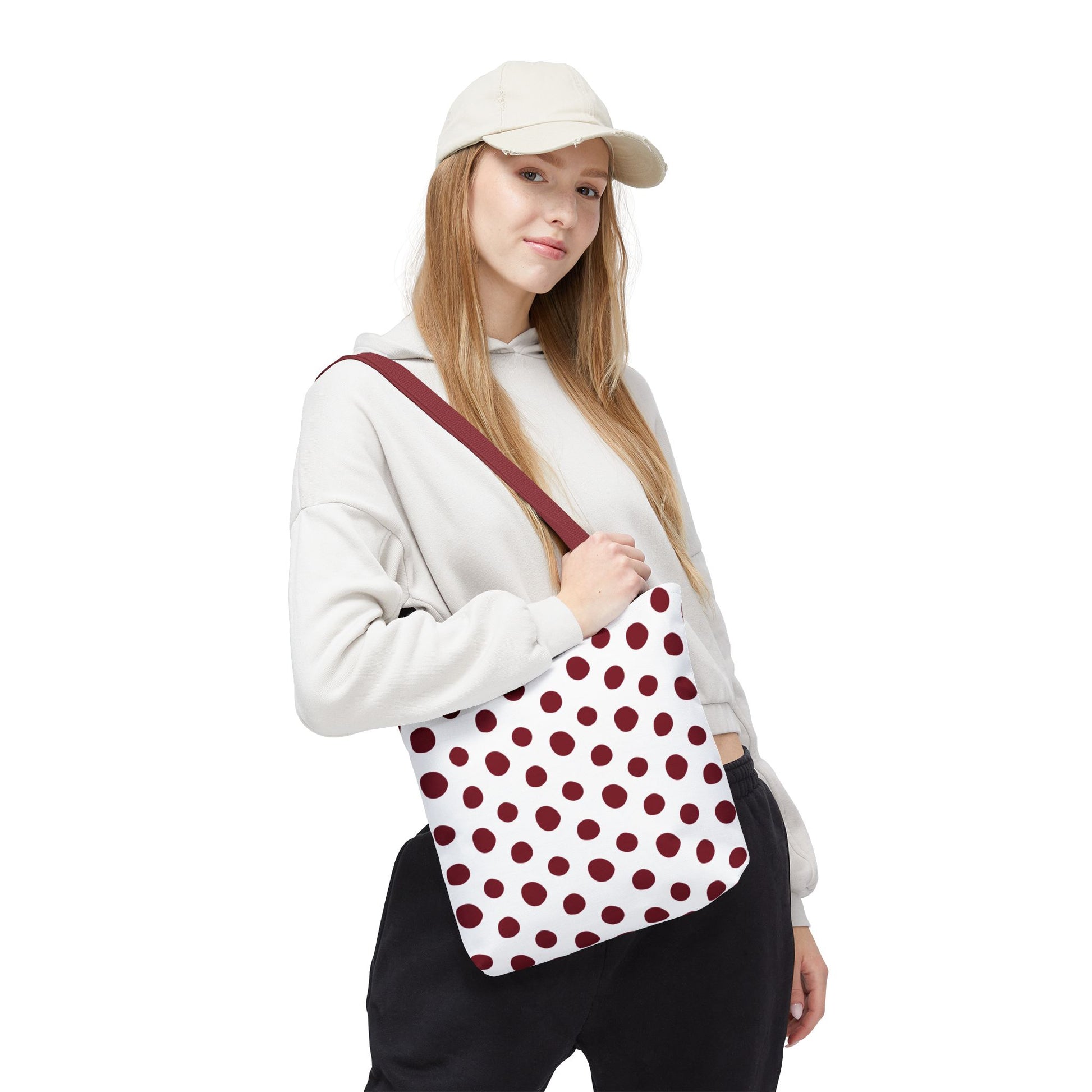 Burgundy Polka Dots Tote Bag held by a hand, showcasing its durable polyester fabric and reinforced handles, perfect for everyday use. A stylish accessory embodying FireBrook Essentials' commitment to comfort and joy.