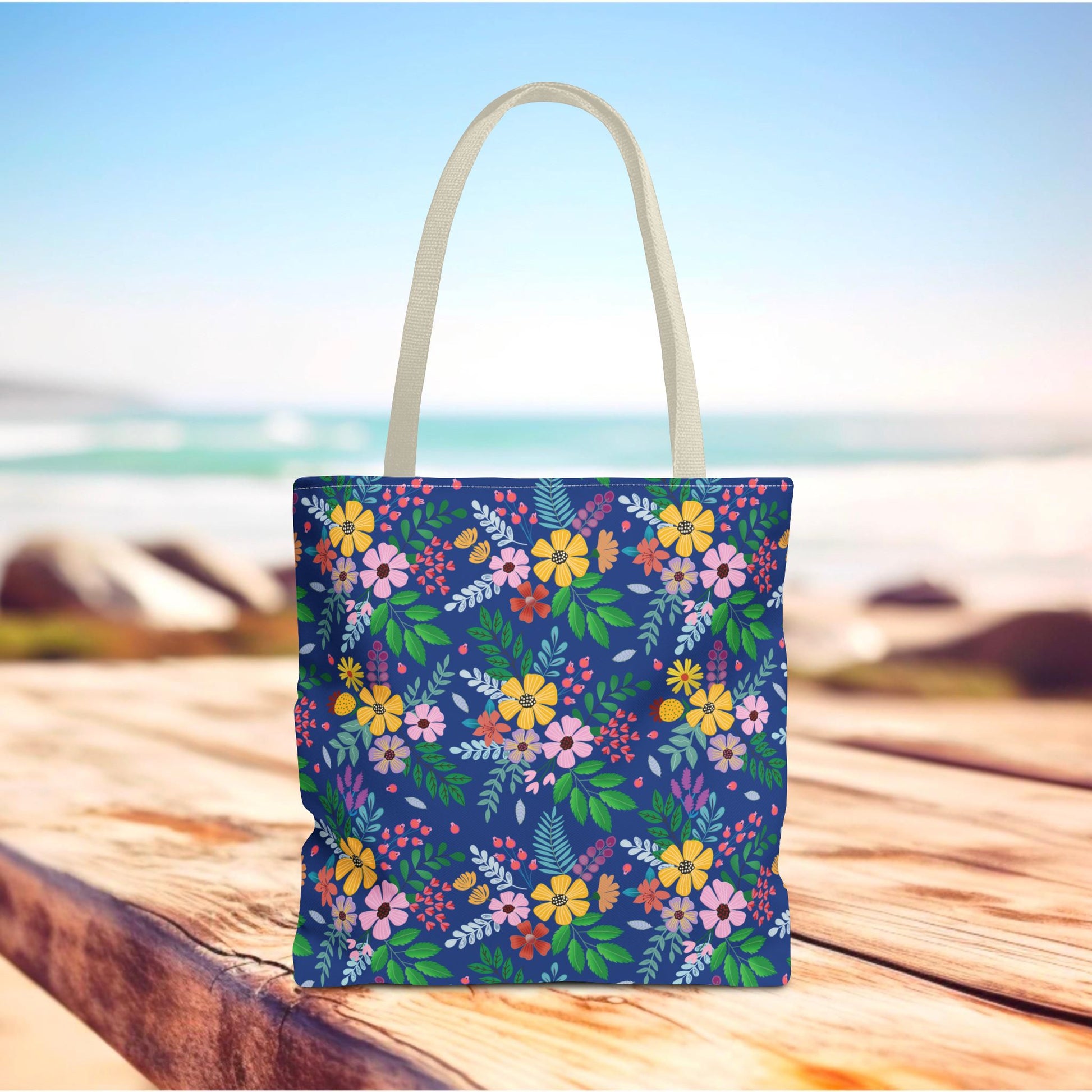Deep Sea Floral Patch Tote Bag on wooden surface, featuring vibrant multicolored blossoms and off-white handles. Perfect for summer outings, this FireBrook Designs bag combines joyful style and practicality.