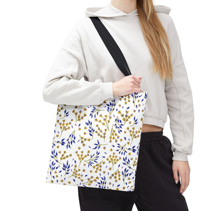 Floral Tote Bag featuring a vibrant botanical print with yellow and blue sprigs, carried by a person in a light hoodie. Perfect for summer outings, embodying FireBrook Designs' cheerful and stylish essence.