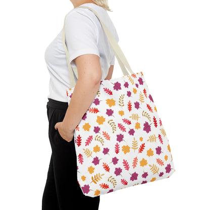 Person holding the Autumn Leaves Tote Bag, featuring a vibrant pattern of stylized autumn leaves, showcasing its spacious design and durability, suitable for everyday essentials.