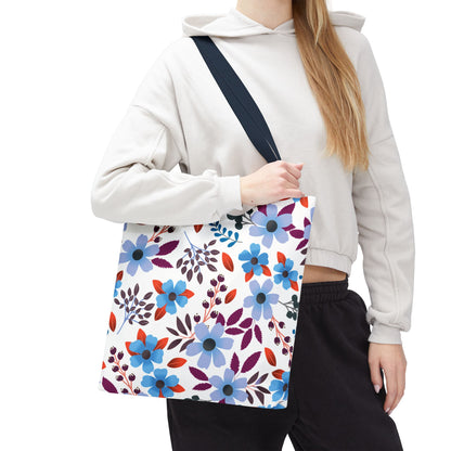 Floral Tote Bag with vibrant blue, red, and purple blossoms, carried by a person wearing a light hoodie. Features dark shoulder strap for comfort, perfect for summer outings by FireBrook Designs.