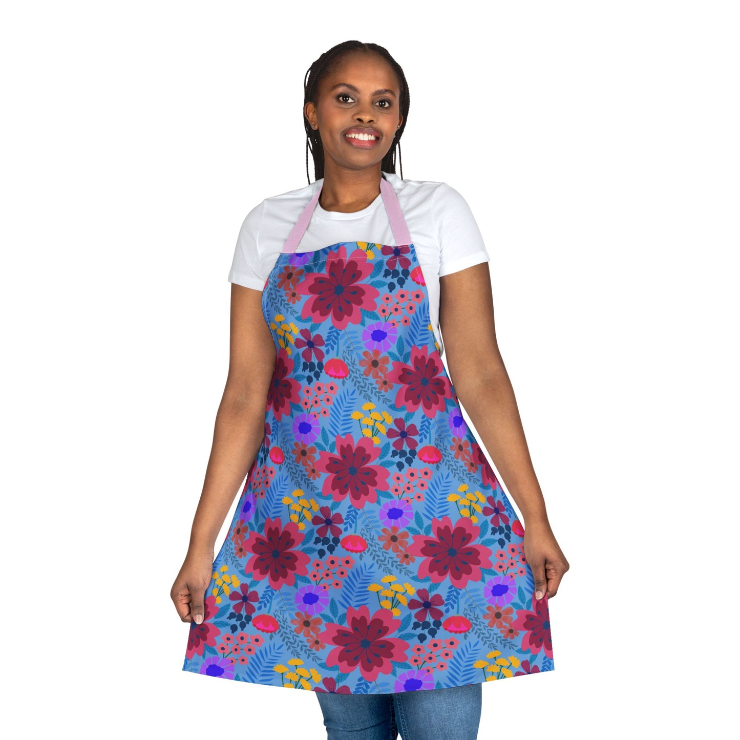 Floral Apron from FireBrook Designs: Woman models a vibrant, multicolored floral apron over casual wear, showcasing its full-coverage design, perfect for keeping clothes stain-free during cooking or crafting.