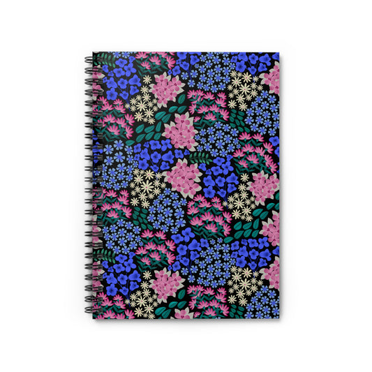 Floral Spiral Notebook with a vibrant all-over floral pattern in blue, pink, and cream on a black background, featuring a sleek metal spiral binding for easy page turning, ideal for creative tasks.