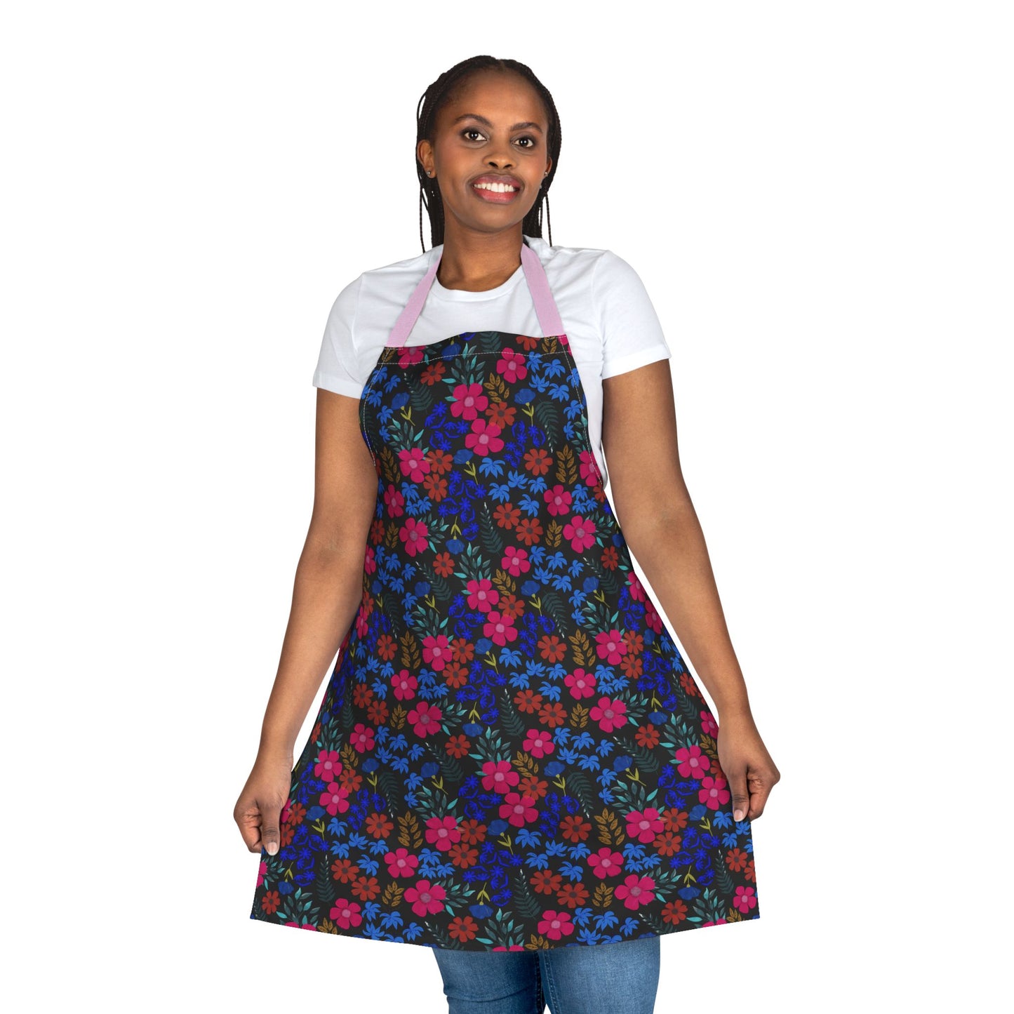 Woman models Apron Floral Design by FireBrook Essentials, showcasing its vibrant floral pattern and pink neck strap. The apron offers full coverage, ideal for cooking or crafting activities.