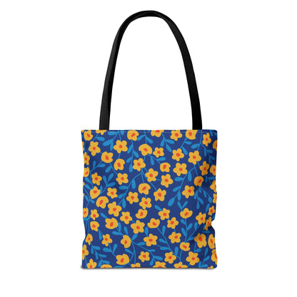 Floral Tote Bag featuring vibrant yellow-orange blossoms with red centers and bright blue leaves on a deep blue background, black shoulder straps, designed for durability and style, perfect for joyful summer outings.