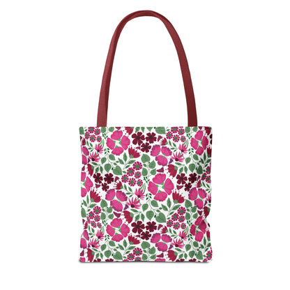 Pink Lady Tote Bag showcasing vibrant pink and magenta floral patterns on a white base, complemented by deep red handles. Ideal for adding a cheerful pop of color to everyday outfits.