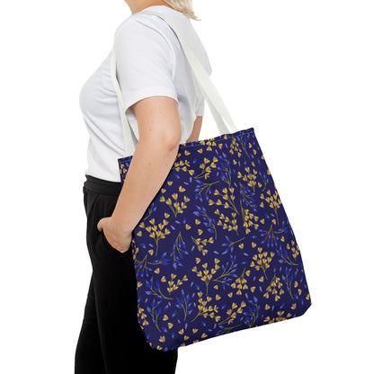 Floral Tote Bag over shoulder, featuring a navy-blue body with yellow buds and blue leaves. Designed for joyful summer outings, this bag embodies FireBrook Essentials' commitment to stylish, uplifting designs.