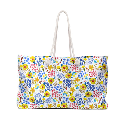 Weekender Bag with thick white rope handles, featuring a vibrant floral pattern on a white background, ideal for stylish weekend getaways. Designed for comfort and joy from FireBrook Essentials.
