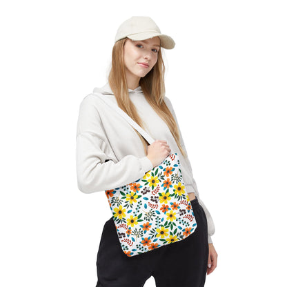 A young woman models the Sunny Meadow Mix Tote Bag, featuring vibrant yellow and orange floral patterns on a white backdrop, embodying FireBrook Designs' cheerful, uplifting style.