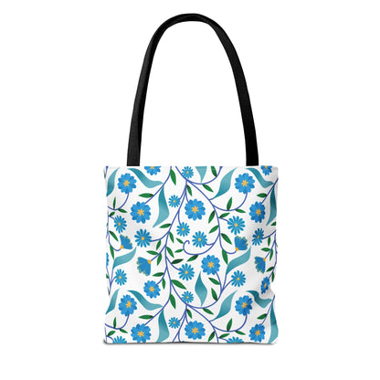 Blue Floral Tote Bag featuring a vibrant botanical pattern with stylized blue flowers, yellow centers, and green leaves on a durable white canvas. Black straps offer strength and style, perfect for cheerful summer outings.