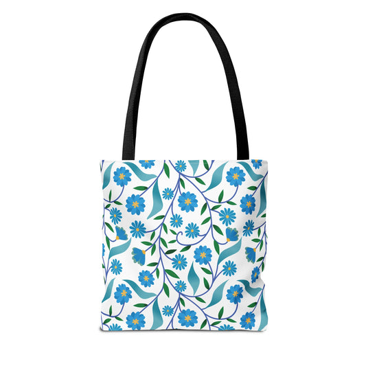 Blue Floral Tote Bag featuring a vibrant botanical pattern with stylized blue flowers, yellow centers, and green leaves on a durable white canvas. Black straps offer strength and style, perfect for cheerful summer outings.