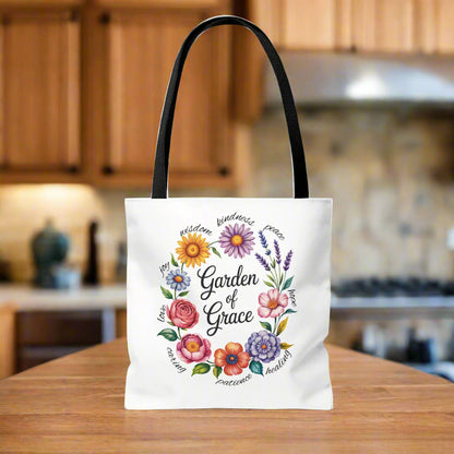Garden of Grace Watercolor Design Tote Bag features hand-drawn flowers in soft pastels with 'Garden of Grace' text. Durable polyester, reinforced handles, perfect blend of nature-inspired charm and everyday functionality.