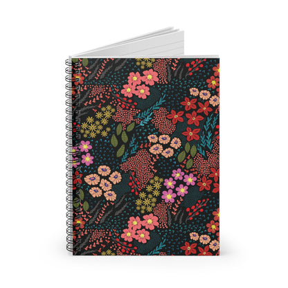 Floral Spiral Notebook featuring a vibrant multicolored floral design with metal spiral binding, standing upright to reveal lined pages. Ideal for creative note-taking and journaling.