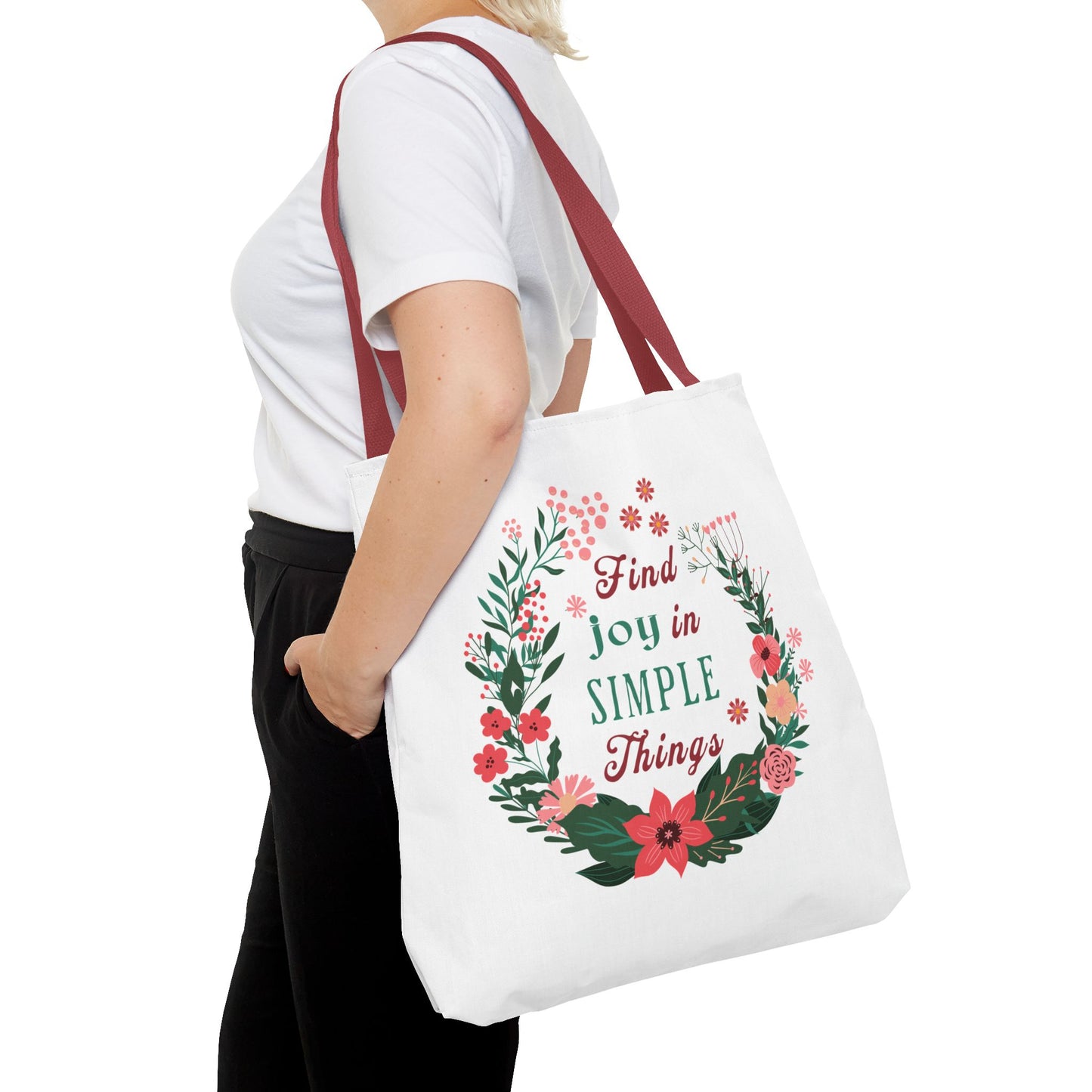 Woman holding the Find Joy in Simple Things tote bag, featuring a watercolor floral design, perfect for stylish, practical use.