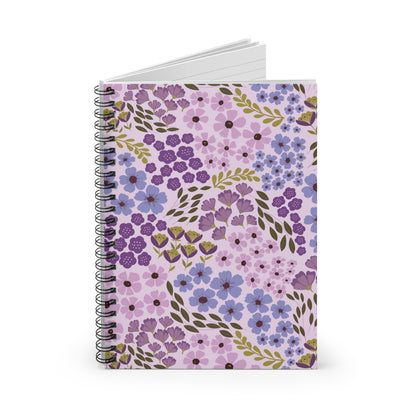 Floral Spiral Notebook showcasing a vibrant floral design with purple, lilac, and blue flowers on a pale lavender cover, slightly open to reveal blank pages, embodying FireBrook Designs' stylish and joyful essence.