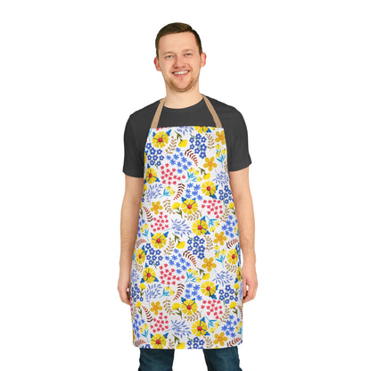 Young man wearing the Apron Floral Design, featuring vibrant floral patterns on a white base, showcasing its comfortable full-coverage fit. Ideal for enhancing cooking or crafting experiences with style and positivity.