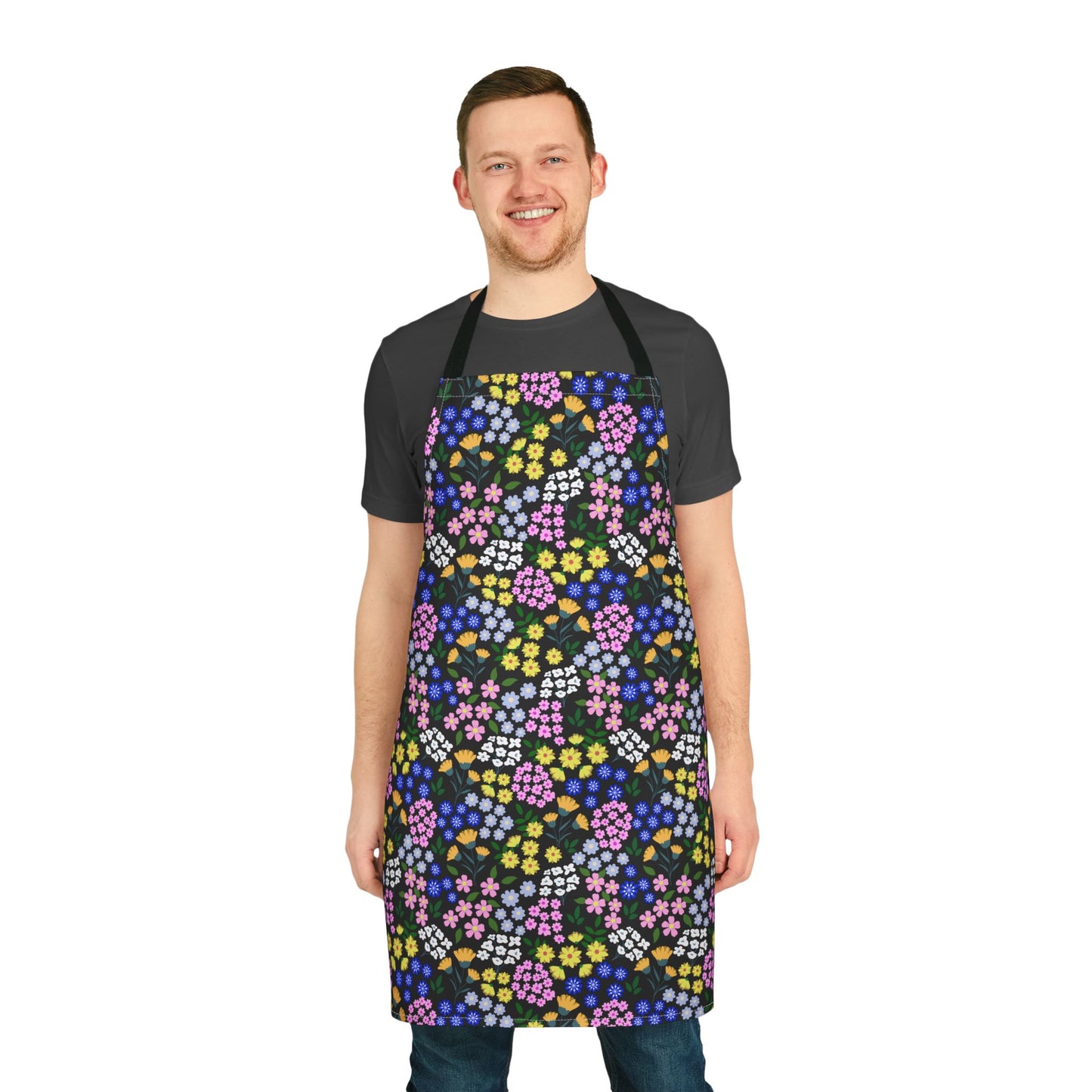 Young man models the Apron Floral Design, showcasing its vibrant, multicolored floral print on a black background, emphasizing comfort with its polyester canvas and foam lining for joyful cooking experiences.