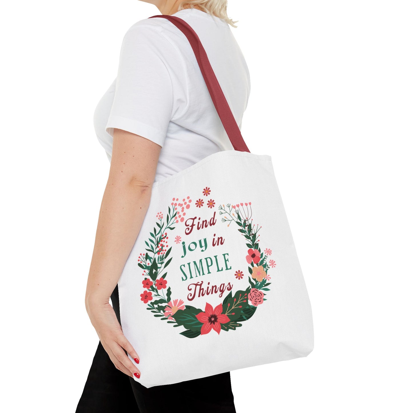 Woman holding the Find Joy in Simple Things Tote Bag with a floral design, highlighting its stylish and durable features. Ideal for daily use and adventures.