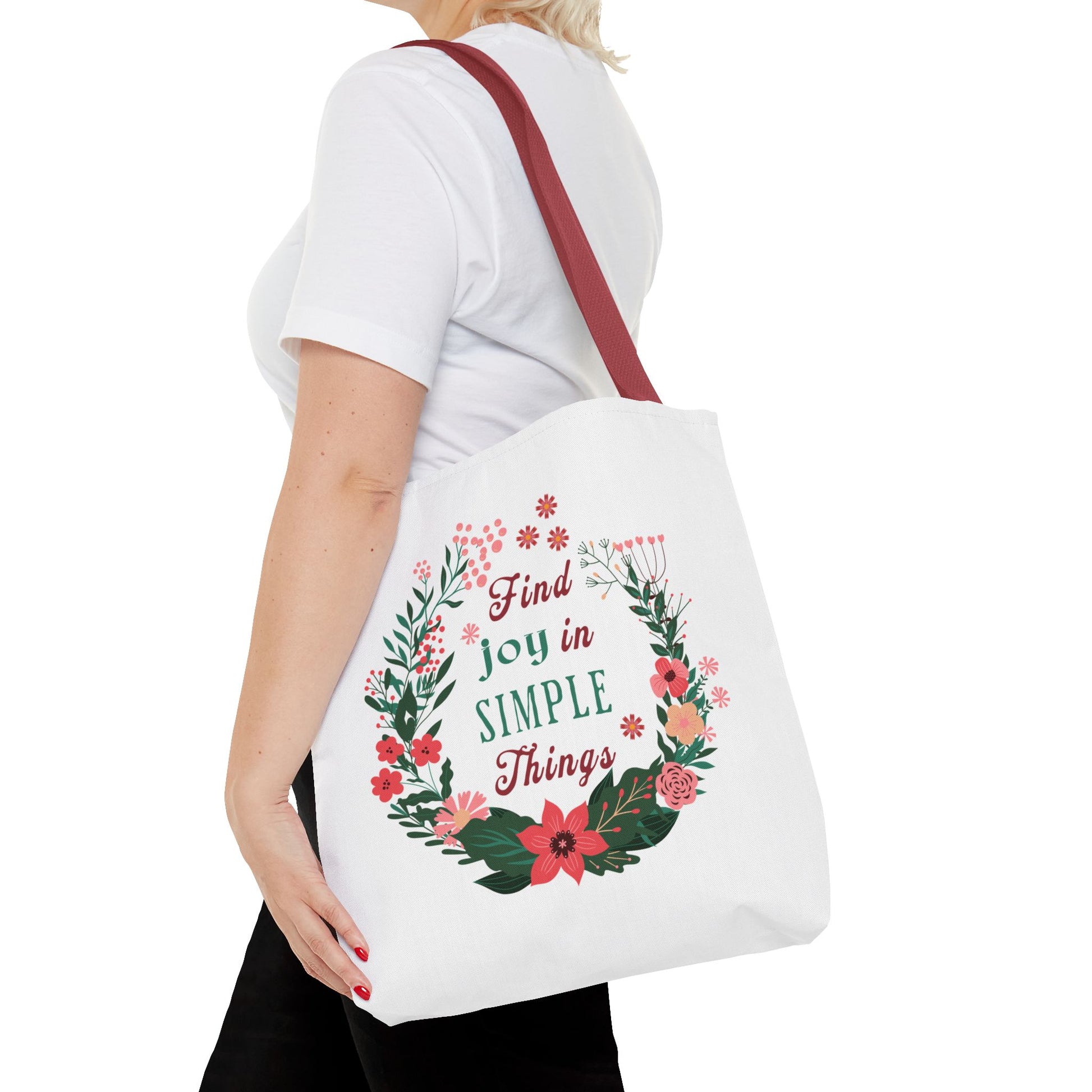 Woman holding the Find Joy in Simple Things Tote Bag with a floral design, highlighting its stylish and durable features. Ideal for daily use and adventures.